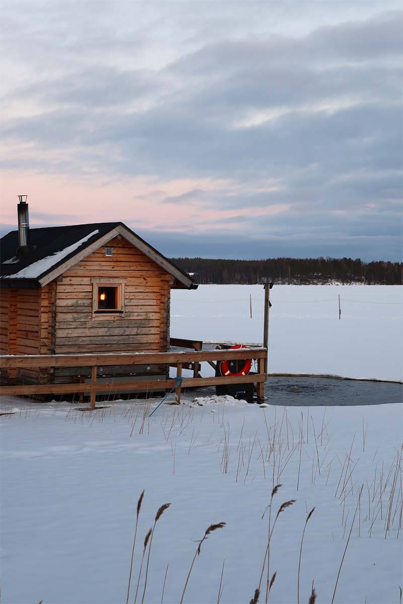 Finnish sauna and ice plunge at a frozen lake in Rovaniemi