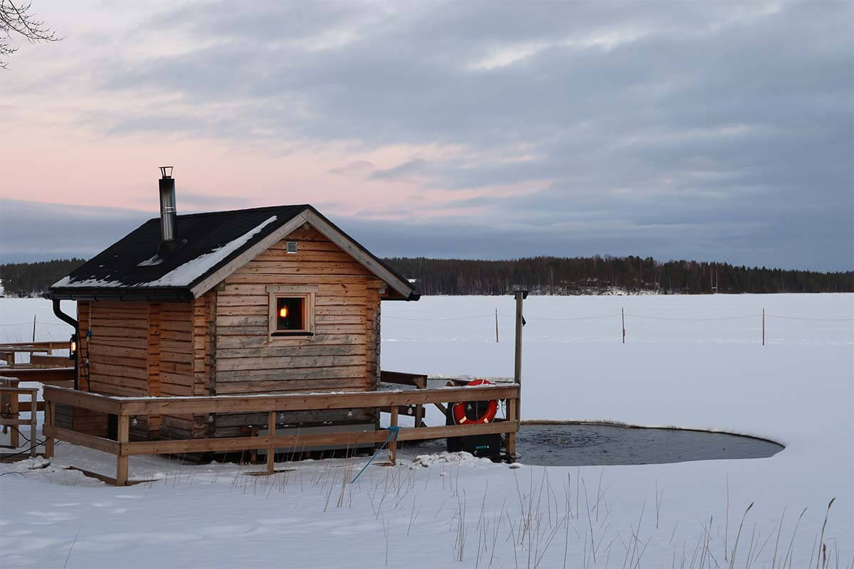 Traditional Finnish sauna and ice plunge at a frozen lake in winter