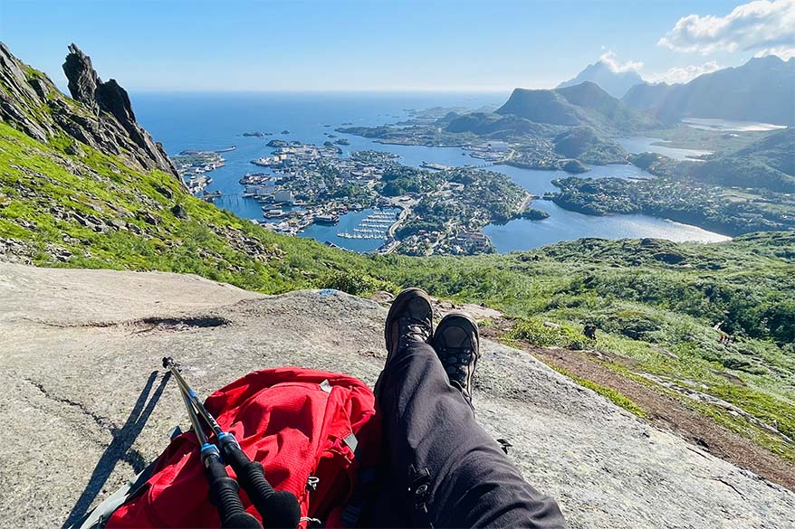 Hiker enjoying the view of Norwegian fjord town in the summer