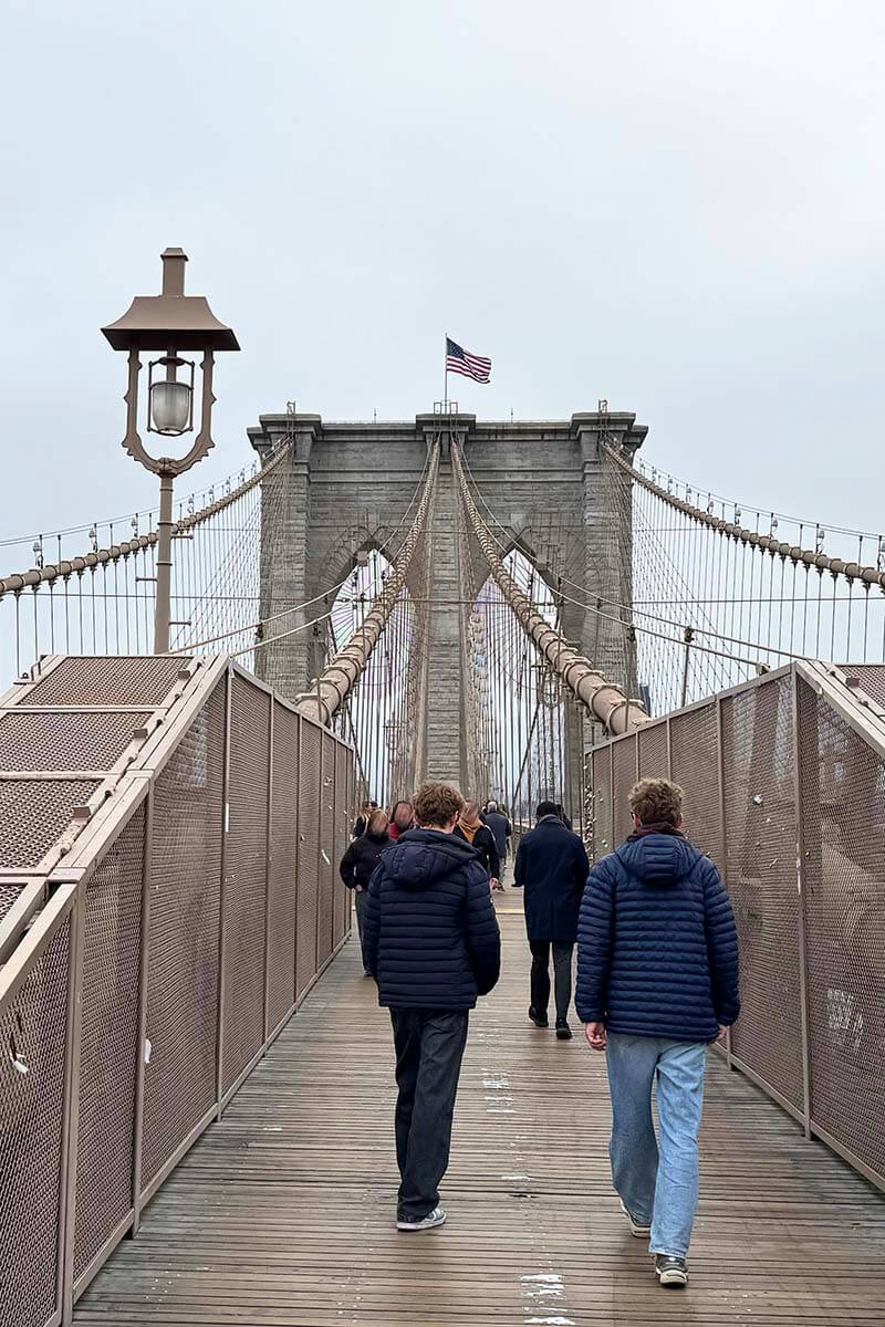 Teens walking over Brooklyn Bridge in NYC