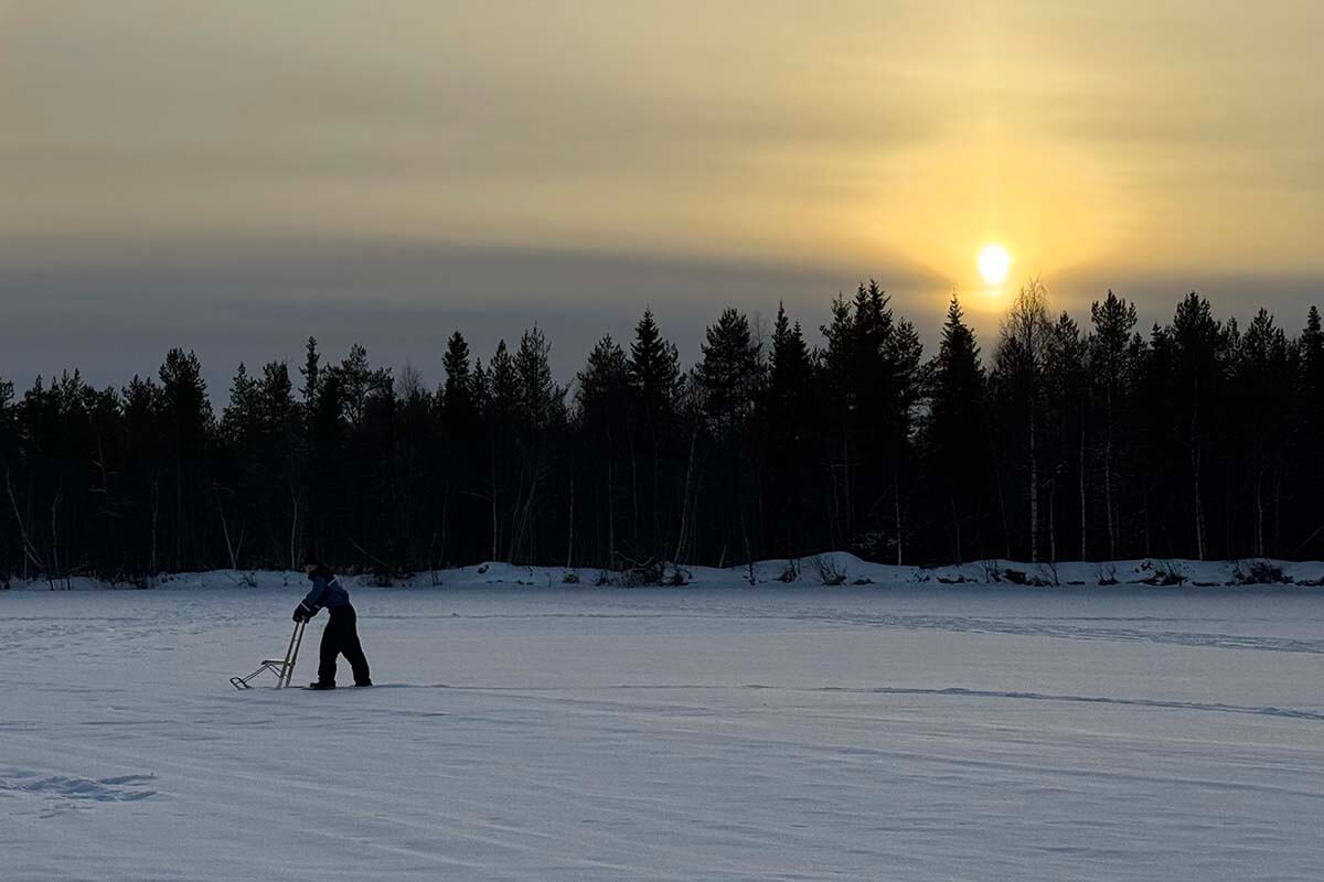 Lapland winter sunset over a frozen lake and forest