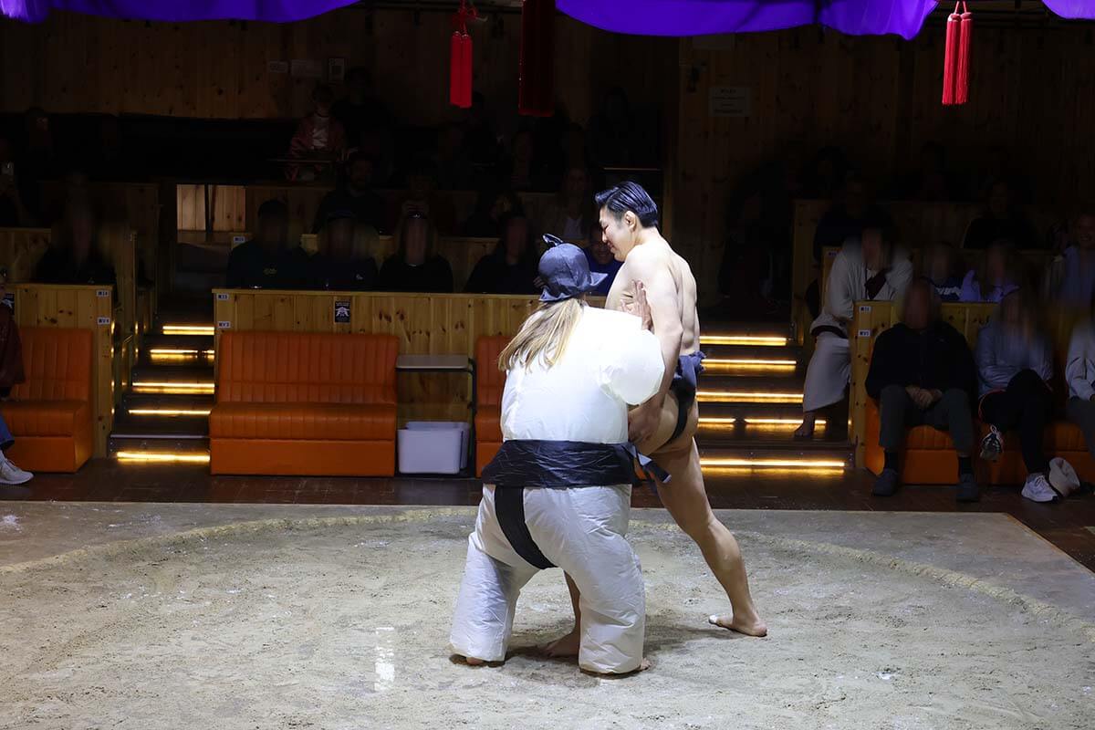 Tourist challenging sumo wrestler at Asakusa Sumo Club in Tokyo Japan