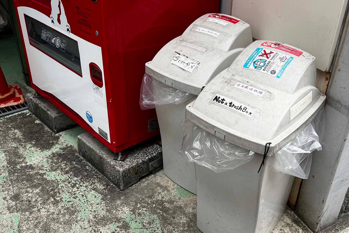 Trash bins with a sign saying it’s not for trash on a street in Japan