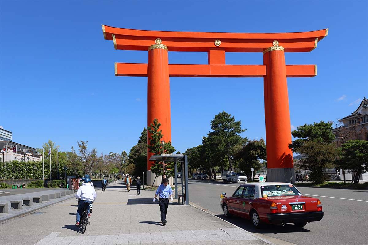 Biking past a huge torii gate at Heian Shrine in Kyoto