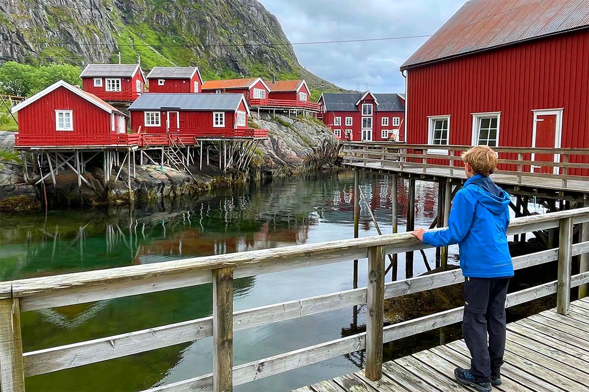 Child wearing hiking pants in the traditional fishing village of A in Lofoten Islands, Norway