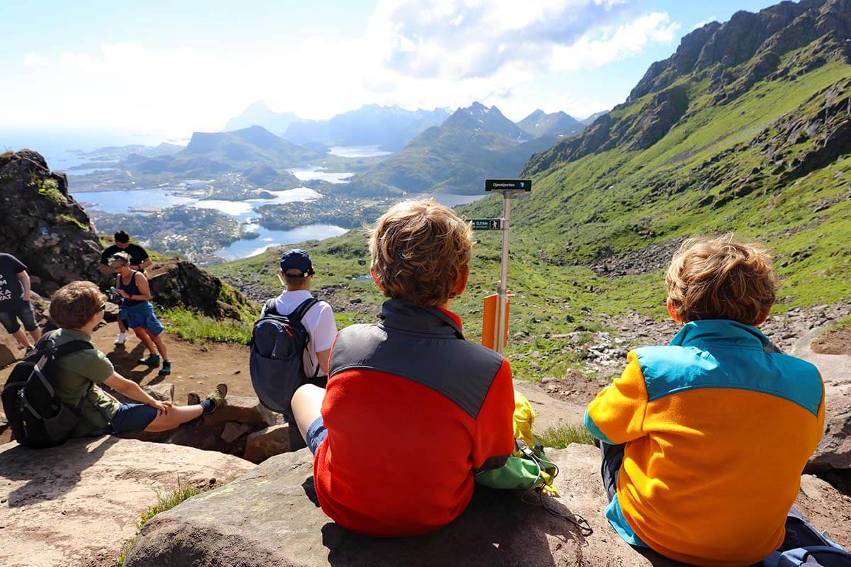 Hikers wearing layered clothing on the Reinebringen trail in the Lofoten Islands, Norway