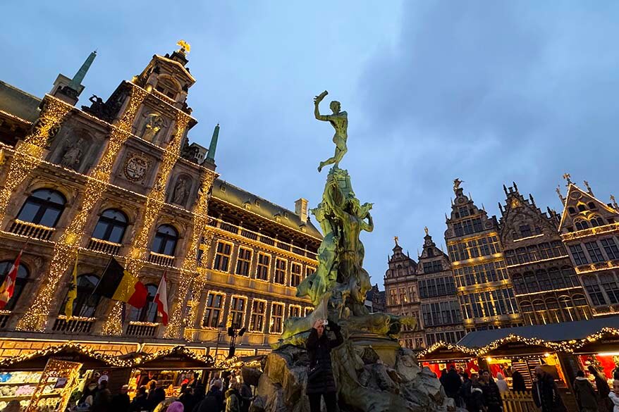 Antwerp City Hall and Brabo Fountain illuminated during the Christmas Market on Grote Markt.