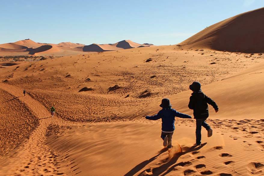 Kids wearing sun hats and lightweight jackets at Sossusvlei dunes in Namibia
