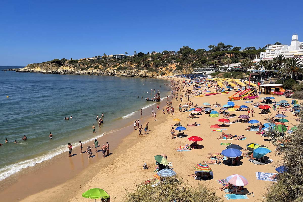 People swimming and sunbathing at Oura Beach in Albufeira end of July