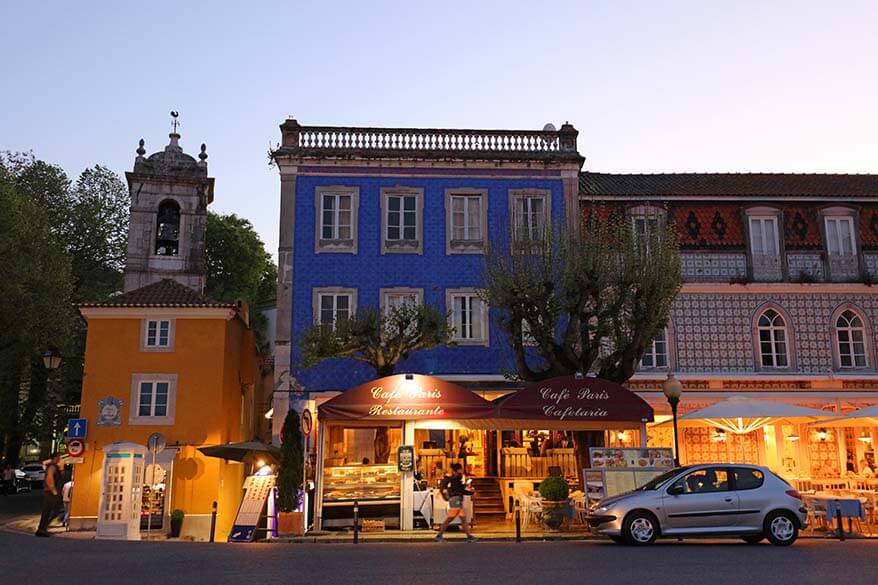 Historic center of Sintra at dusk with colorful buildings, cafés, and restaurants.