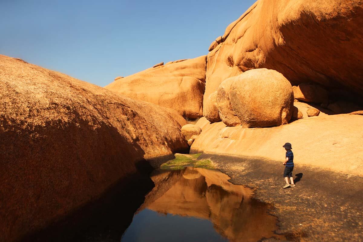 Child by a water pool at Spitzkoppe, Namibia
