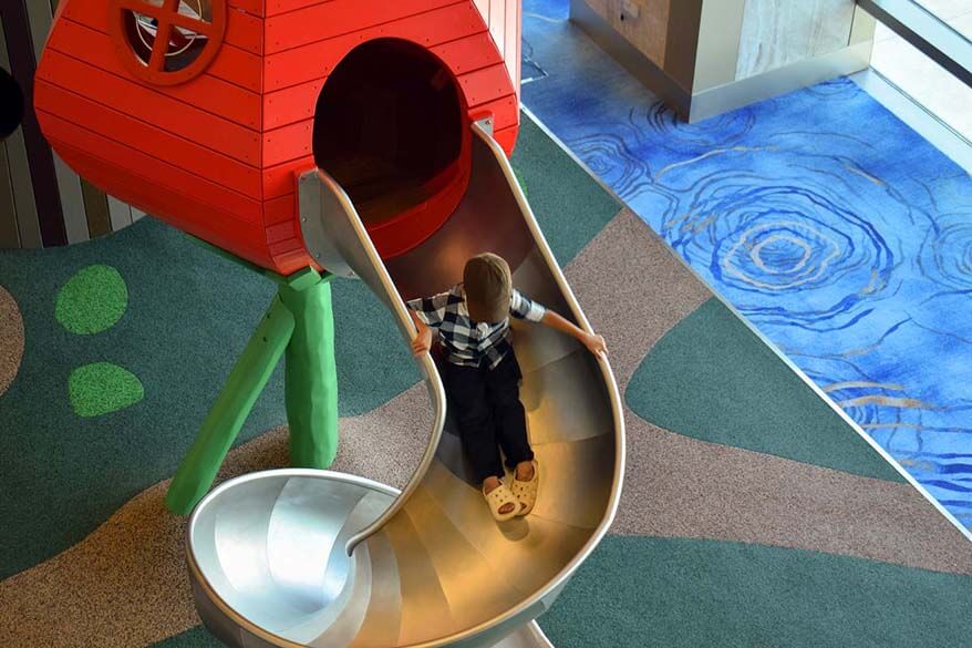 Child sliding down the slide at an airport playground